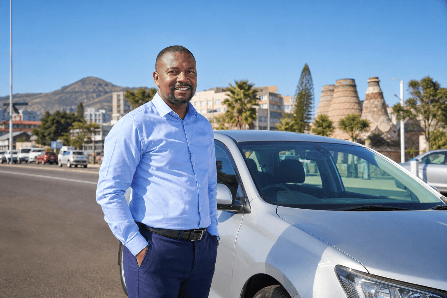 MobiRide driver partner beside a sedan